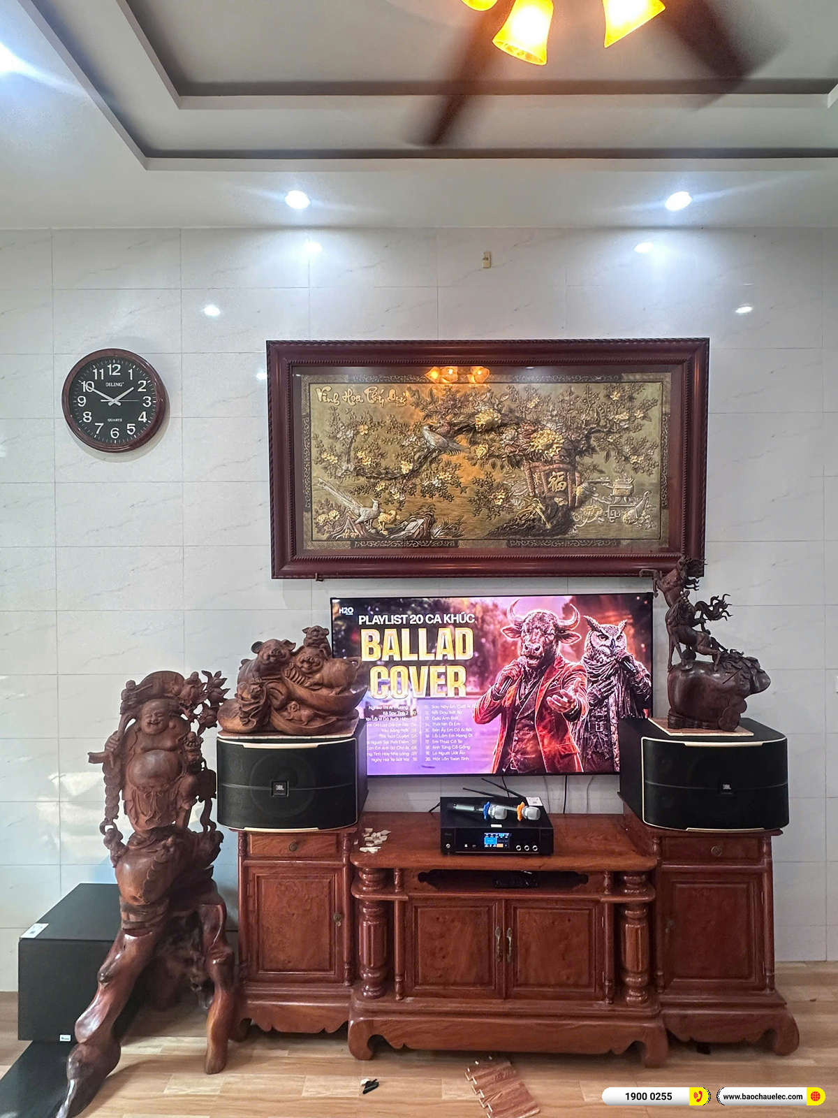 BKSound DKA 8500 đặt giữa kệ dưới tivi, hai tay micro kh&ocirc;ng d&acirc;y nằm tr&ecirc;n m&aacute;y trong to&agrave;n cảnh d&agrave;n karaoke anh Hải